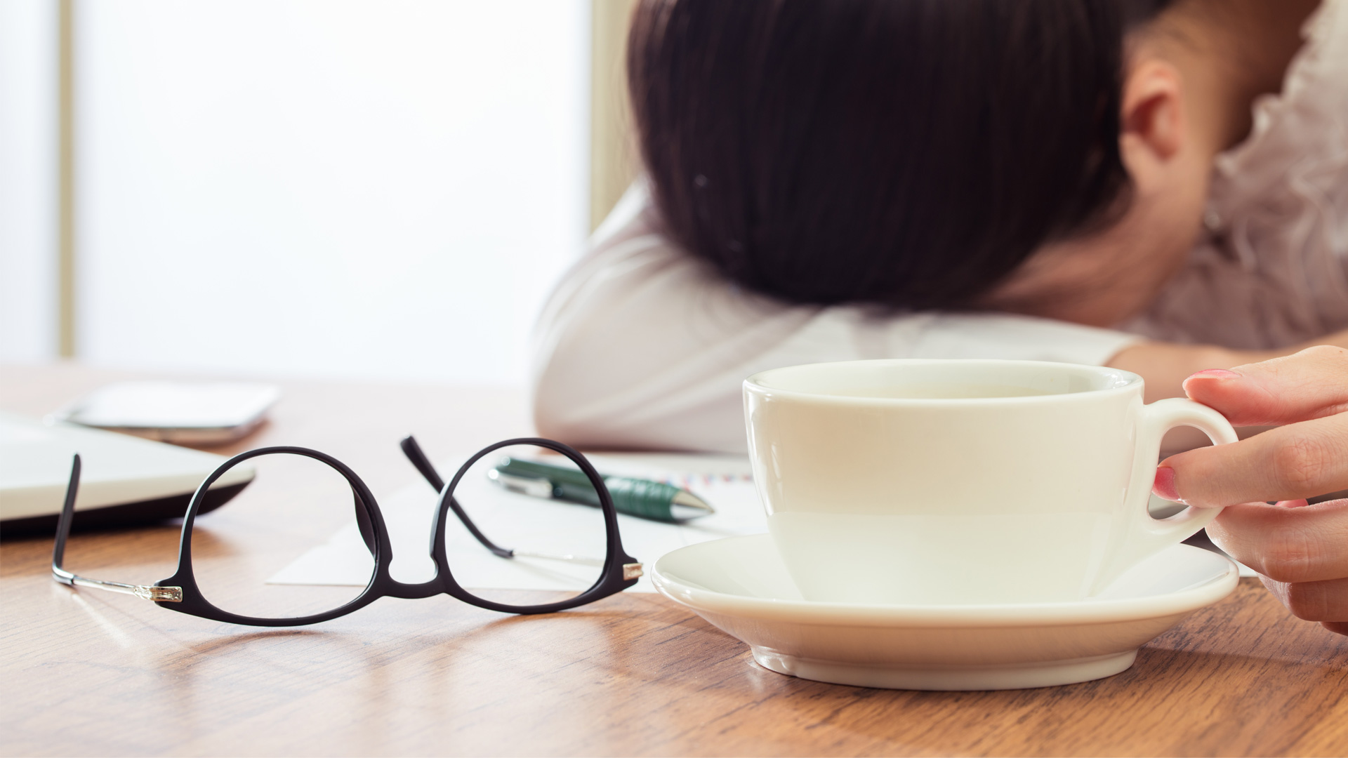 Utmattning vid typ 1-diabetes, diabetes burnout. Person med kaffekopp som vilar huvudet mot armvecket